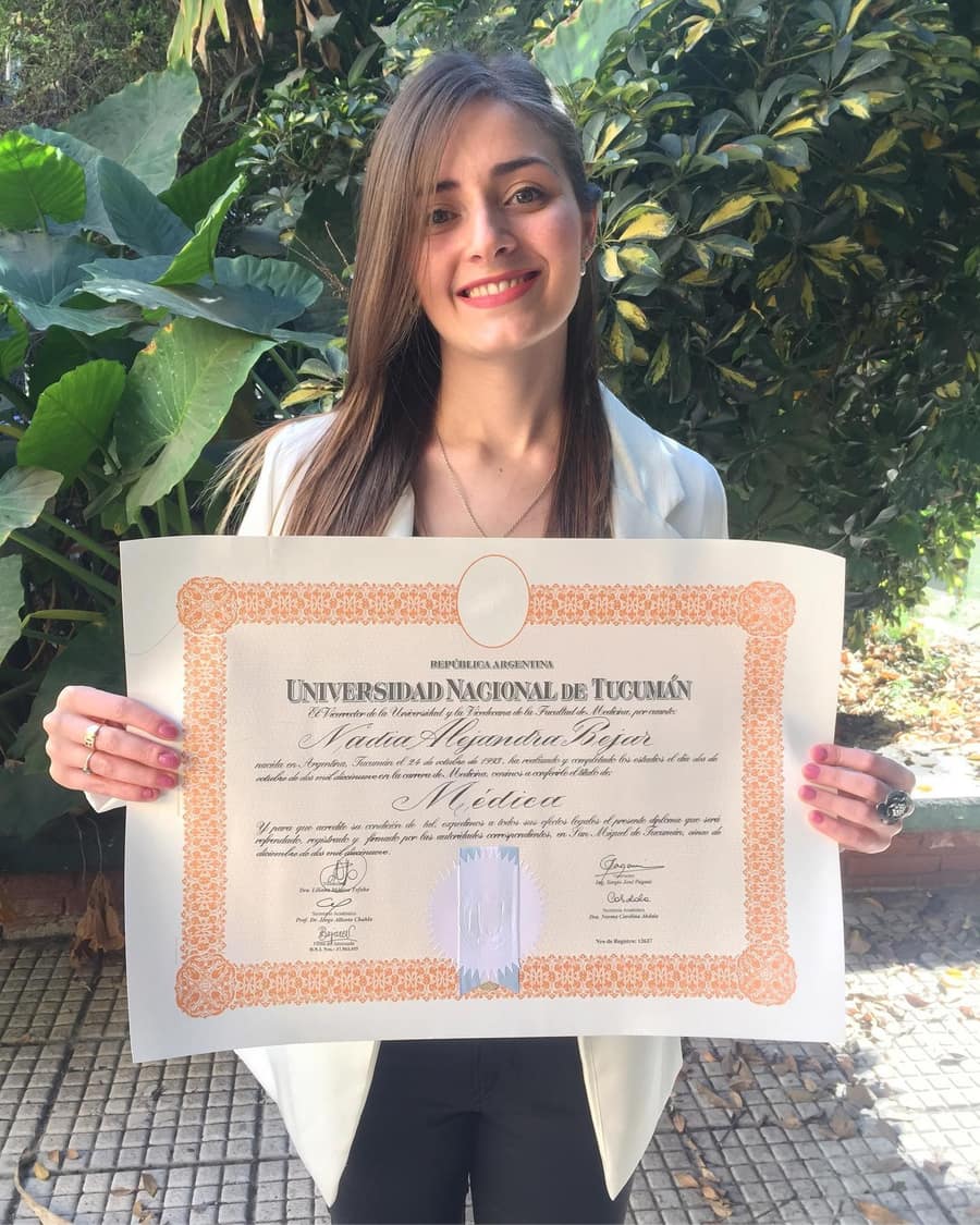 Nadia Bejar sonriendo al aire libre con su diploma de Médica de la Universidad Nacional de Tucumán